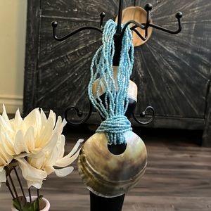 Handmade Artisan necklace made out of beads and seashell.